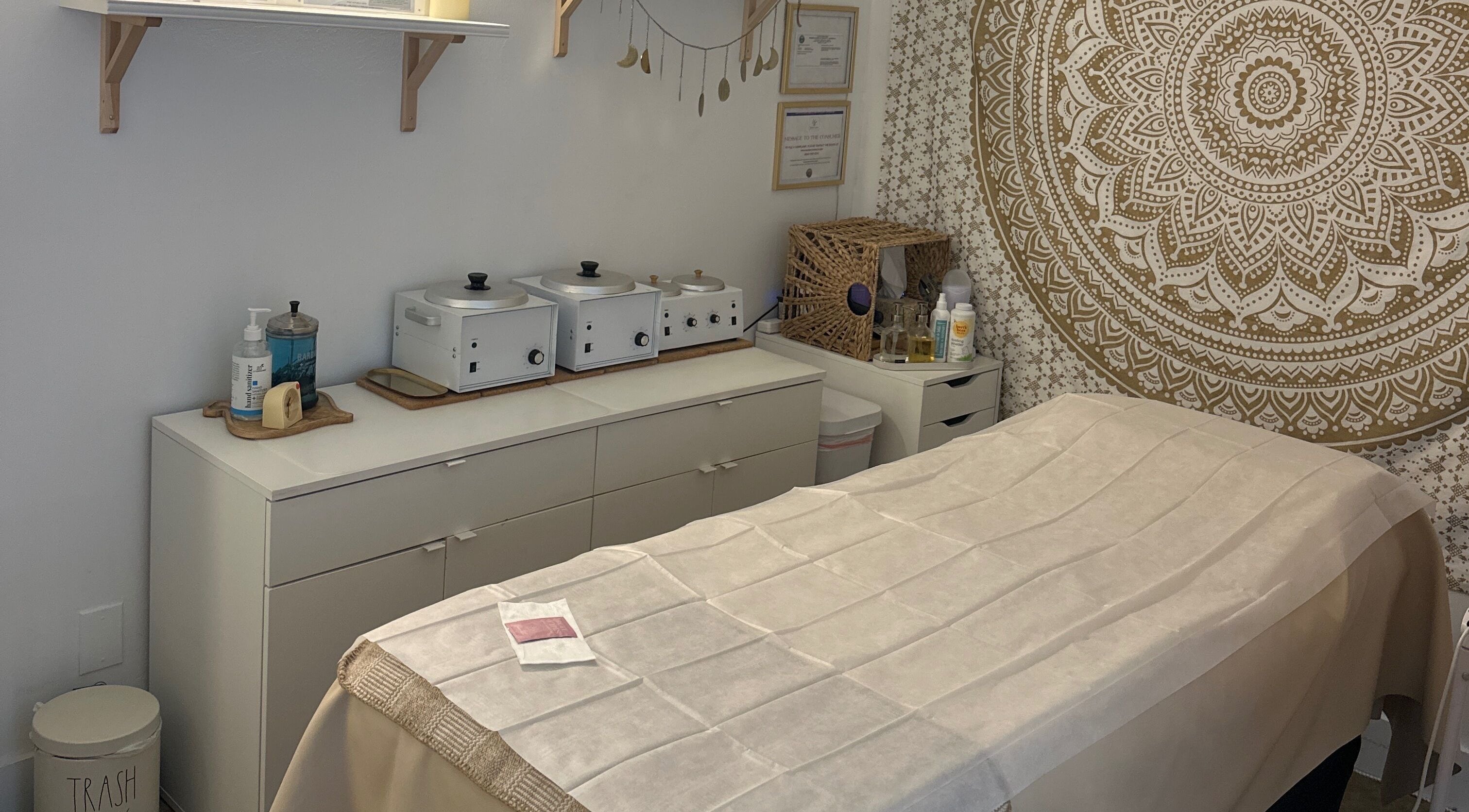 Serene treatment room at SB Artistry, Costa Mesa, California with soothing decor and a massage table.