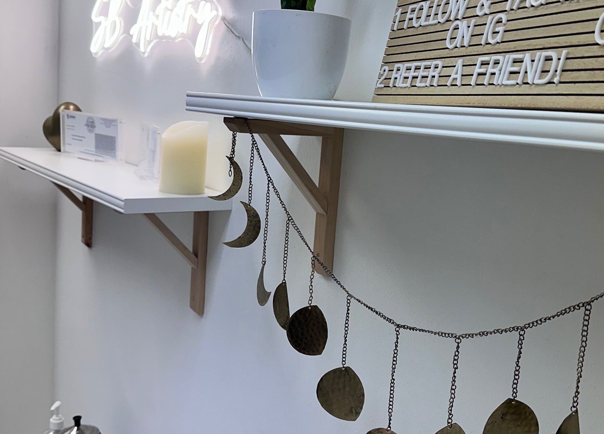 Decorative wall at SB Artistry with moon garland and signs, Costa Mesa, California, US.