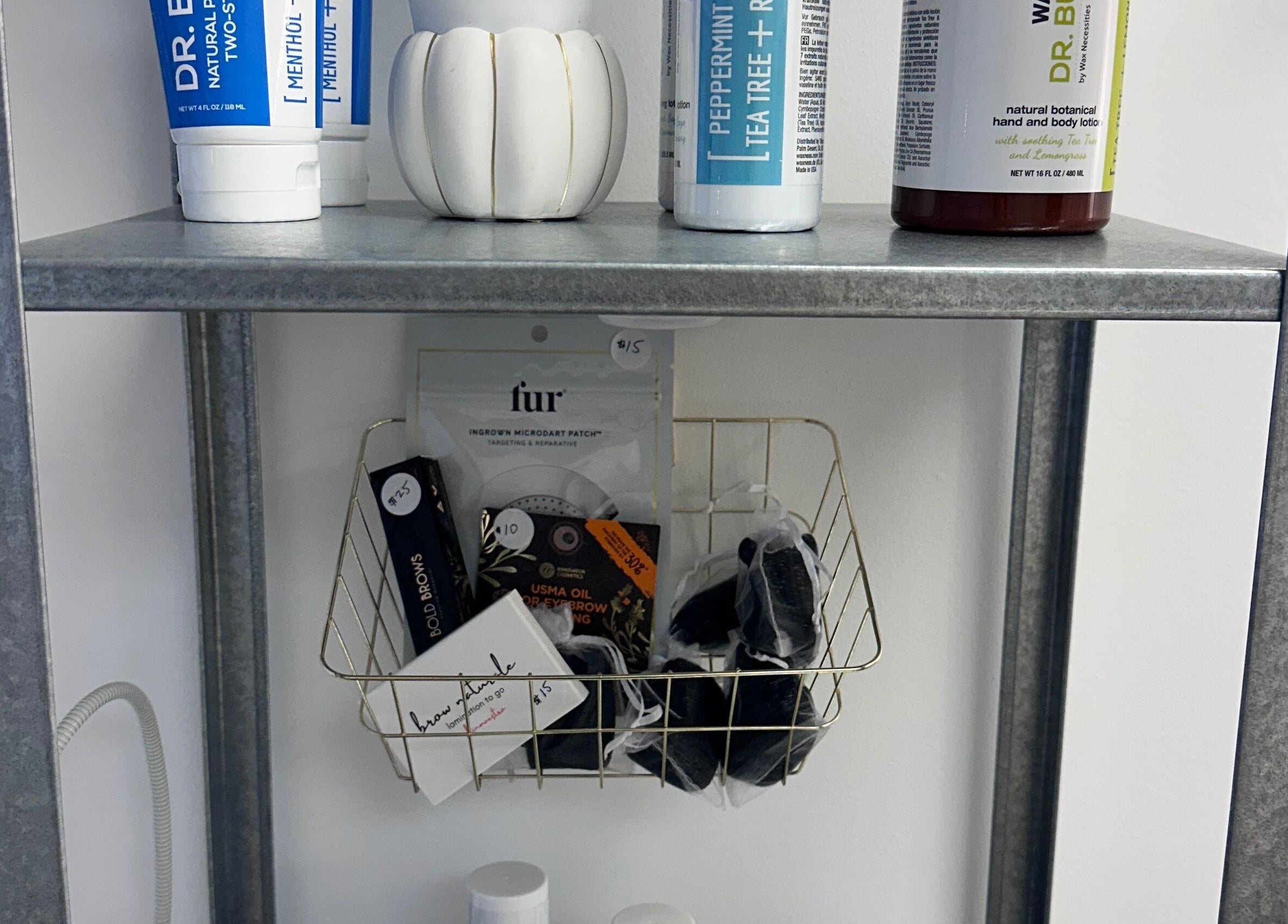 Beauty products on a metal shelf at SB Artistry, Costa Mesa, California, US, for wellness and skincare.