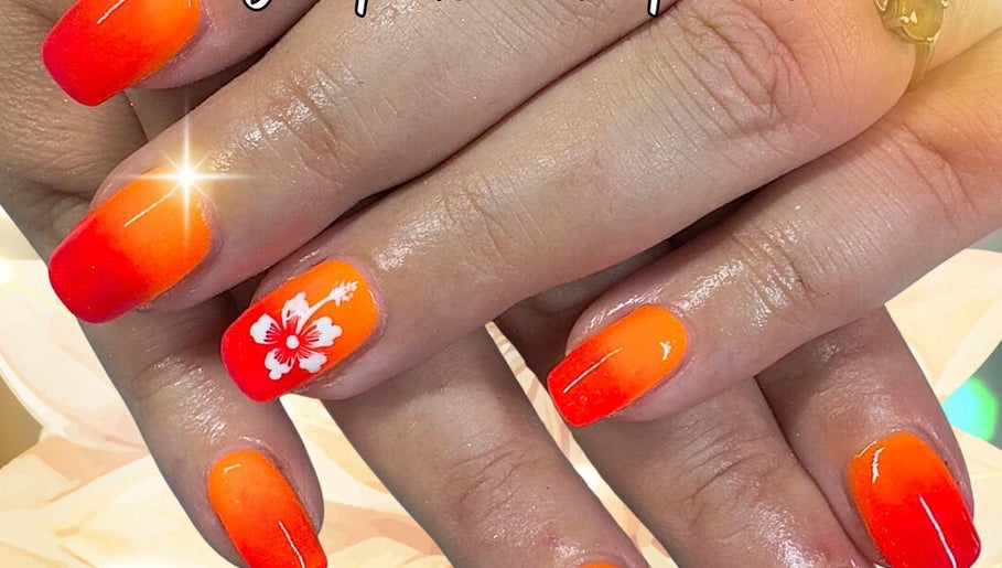 Vibrant orange nails with floral design at The Nail Sanctuary Blackpool, Blackpool, England, GB.
