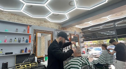 Stylists at work in Hm Barbers, London, England, GB, creating precise cuts under sleek modern lighting.