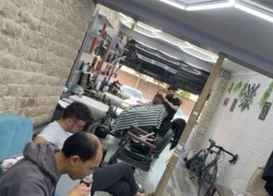 Customers relaxing at Hm barbers in London, England, GB, enjoying upscale grooming services.