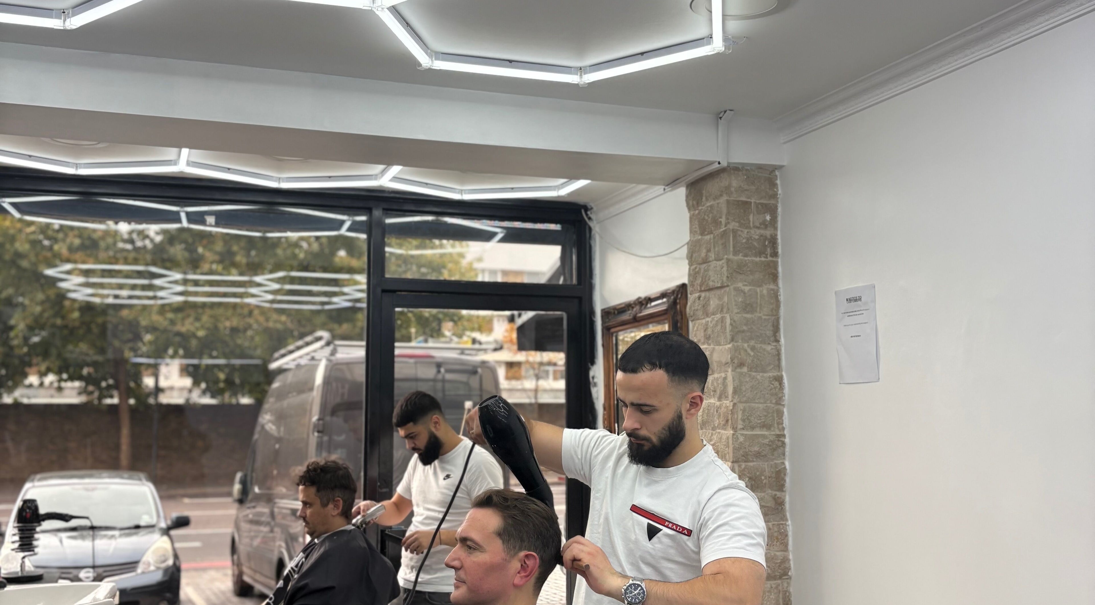Barber styling hair at Hm Barbers, London, England, GB, with modern interior and attentive service.