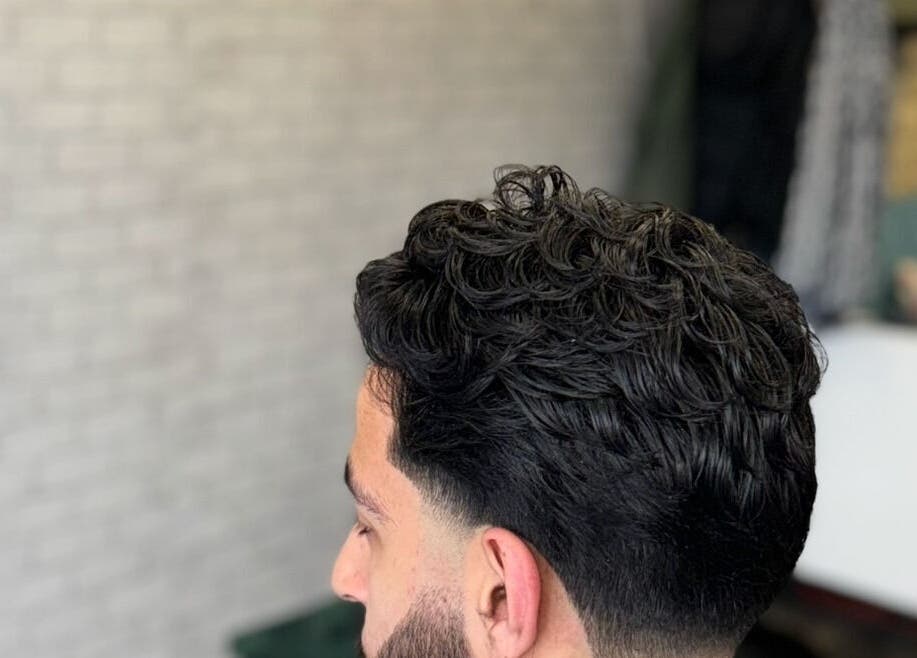 Modern men's hairstyle at Hm Barbers, London, England, GB, showcasing a trendy textured look.