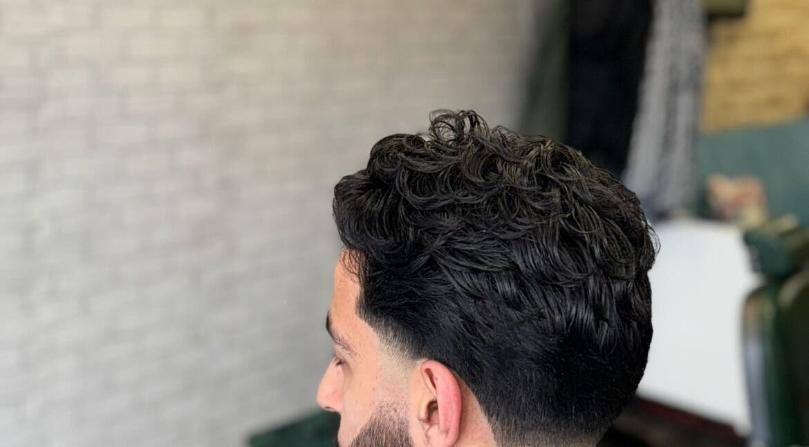 Modern men's hairstyle at Hm Barbers, London, England, GB, showcasing a trendy textured look.