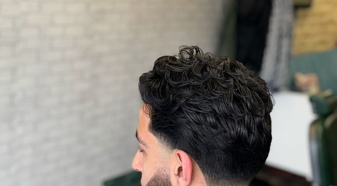 Modern men's hairstyle at Hm Barbers, London, England, GB, showcasing a trendy textured look.