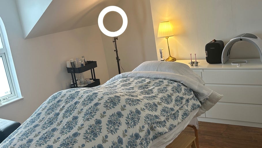 Cozy treatment room at Rebecca Duffy Advanced Skin in Belfast, Northern Ireland, GB, featuring a floral-covered bed.