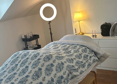 Cozy treatment room at Rebecca Duffy Advanced Skin in Belfast, Northern Ireland, GB, featuring a floral-covered bed.
