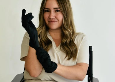 Beauty professional at Afterglow Beauty Ltd in Goole, England, wearing black gloves, ready for treatment.