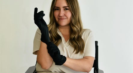 Beauty professional at Afterglow Beauty Ltd in Goole, England, wearing black gloves, ready for treatment.