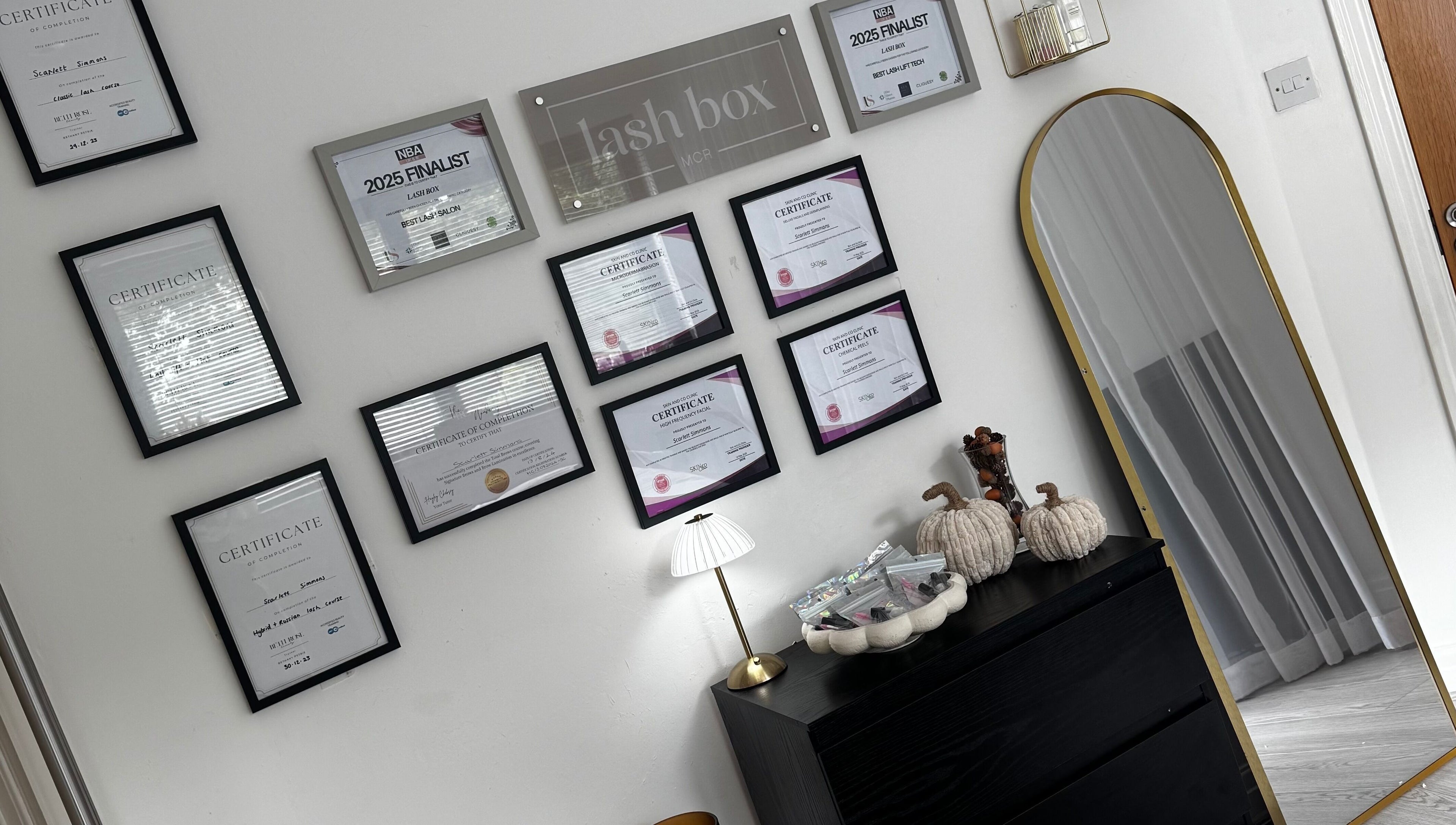 Lash Box Mcr, Greenmount, England showcases an elegant wall of accolades and certifications.