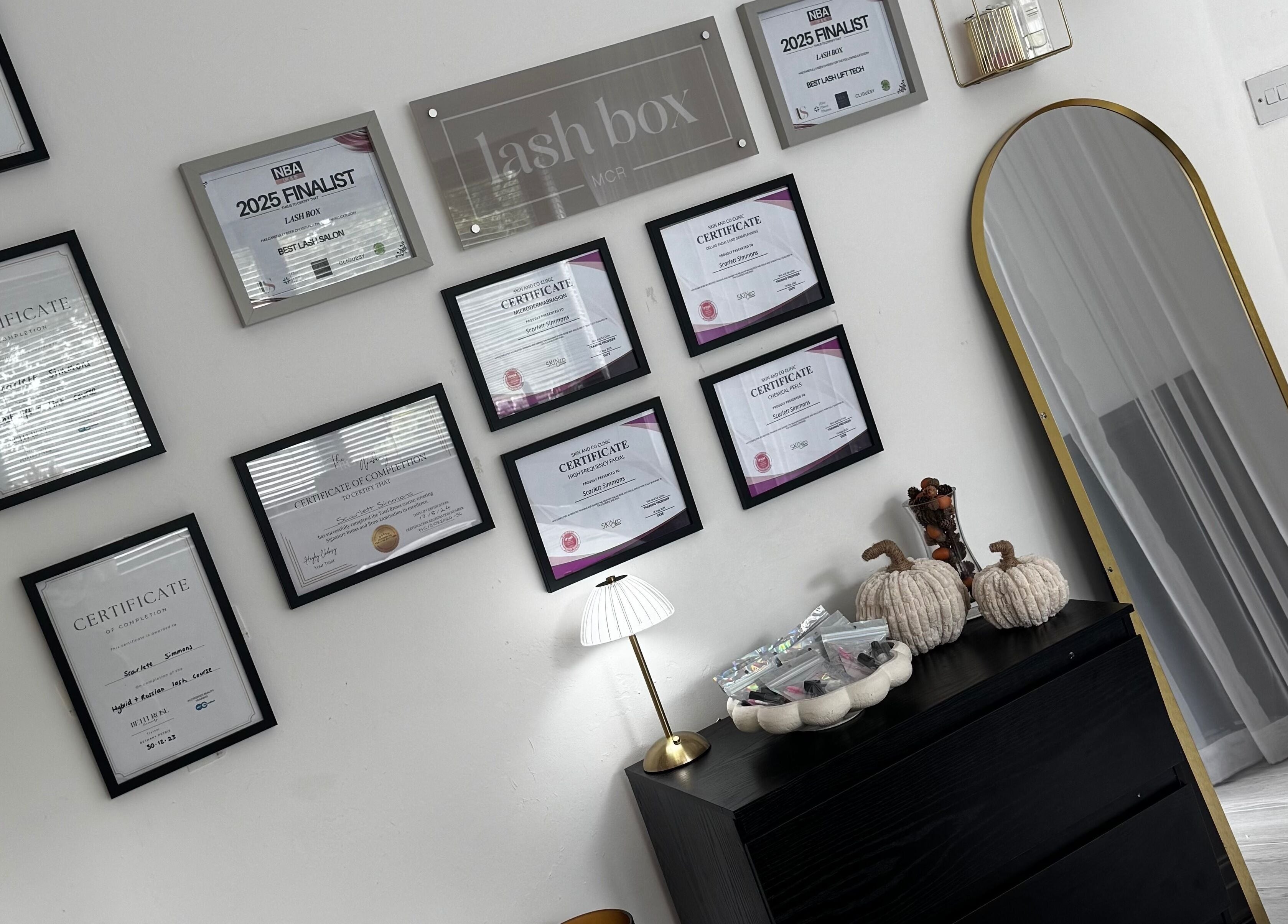 Lash Box Mcr, Greenmount, England showcases an elegant wall of accolades and certifications.