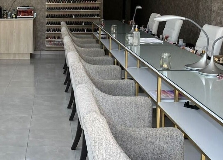 Mesa de manicura en Bonne Vivante, Monterrey, Nuevo León, MX con sillas modernas y lámparas elegantes.
