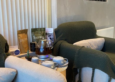 Cozy tea corner at Body D Tox, Melbourne, with knitted green throw, tea set, and herbal products.