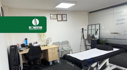 Serene therapy room at Momentum ST, Birmingham, England, GB with a massage table and desk setup.