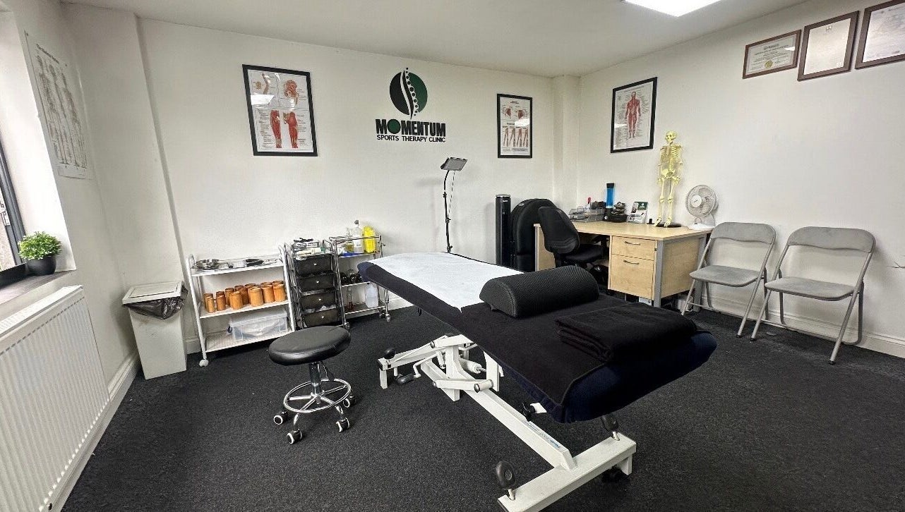 Massage therapy room at Momentum ST, Birmingham, England, GB, featuring a treatment table and anatomical decor.
