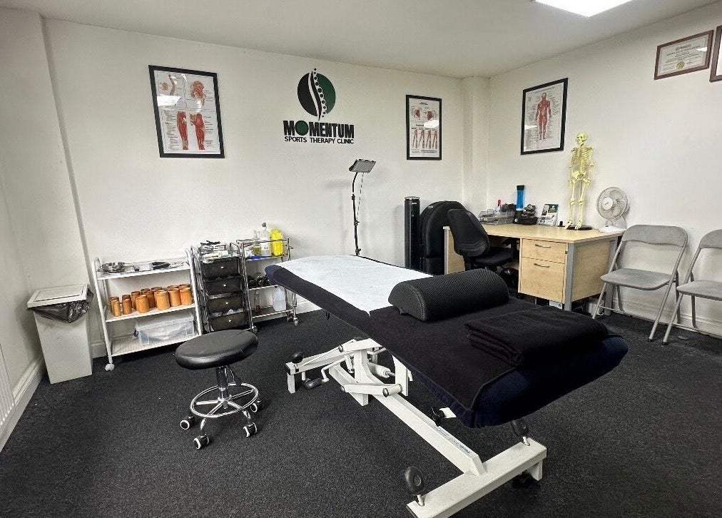 Massage therapy room at Momentum ST, Birmingham, England, GB, featuring a treatment table and anatomical decor.