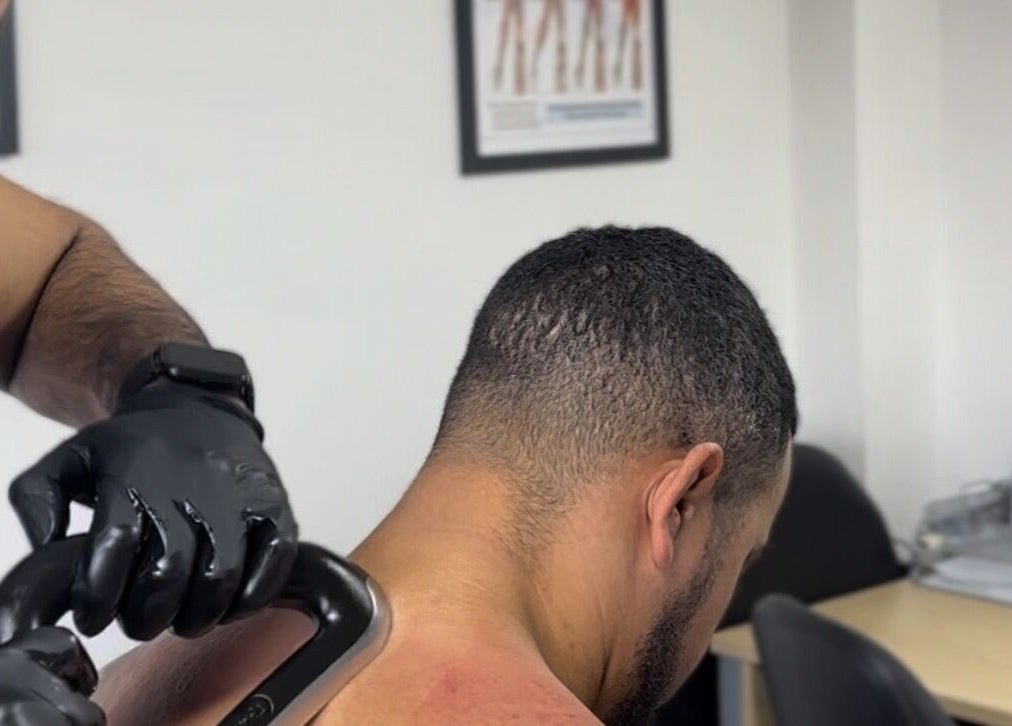 Therapist applies muscle therapy at Momentum ST, Birmingham, England, GB for soothing relief.