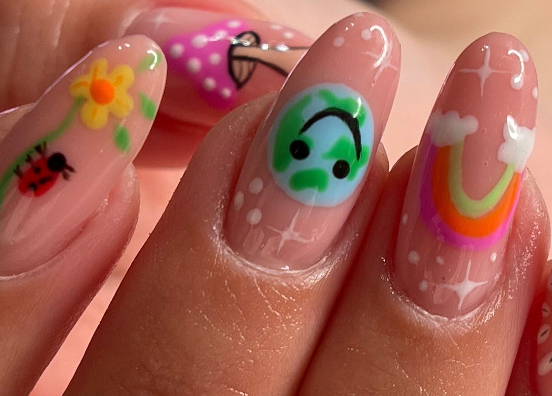 Uñas con diseños creativos en Retouch Nails, Aguada, Aguada, PR, mostrando flores y arcoíris vibrantes.