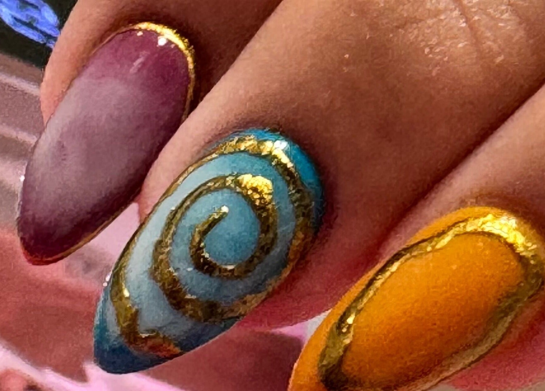 Arte de uñas colorido con diseño espiral dorado en Retouch Nails, Aguada, Aguada, PR.