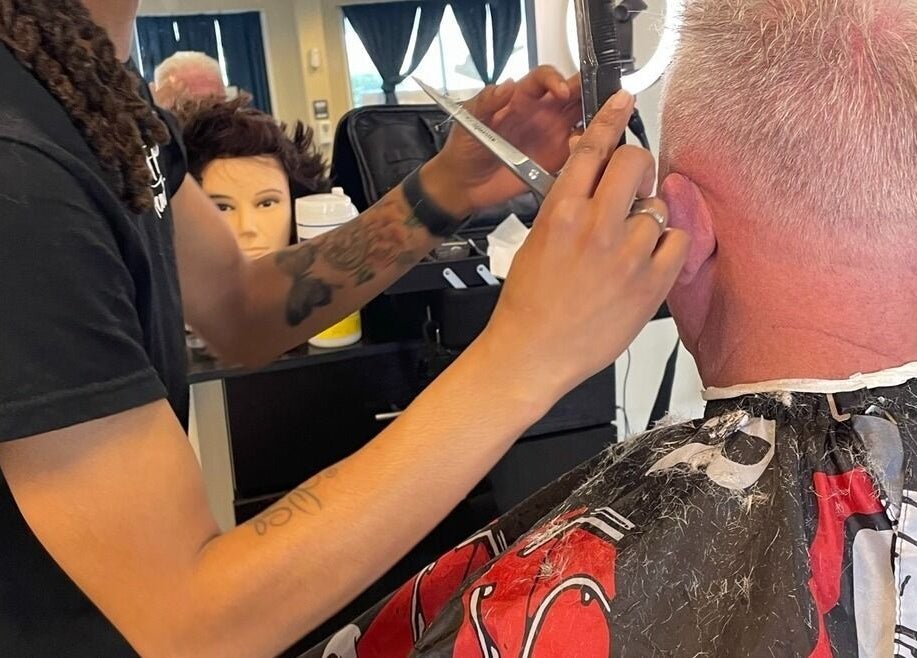 Barber skillfully cutting hair at Uncut Barber Academy, Savannah, Georgia, US.