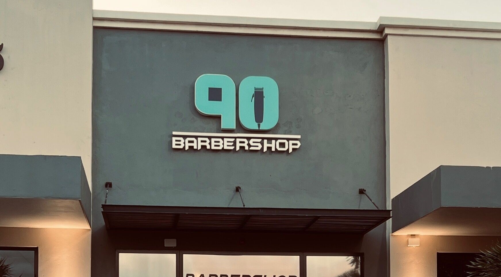 Front facade of Barbershop90 in Willemstad, Curaçao, CW, showcasing its stylish logo and modern exterior.