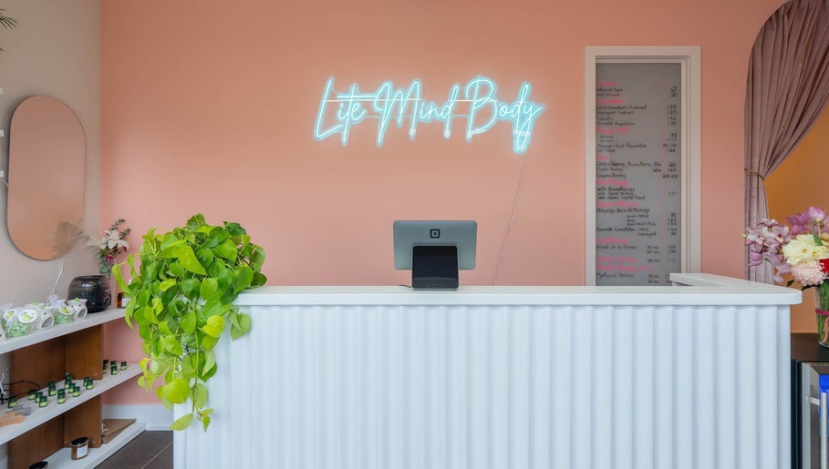 Reception at Lite Mind Body Clinic - Harbord Village in Toronto, Ontario, CA with neon sign and plants.