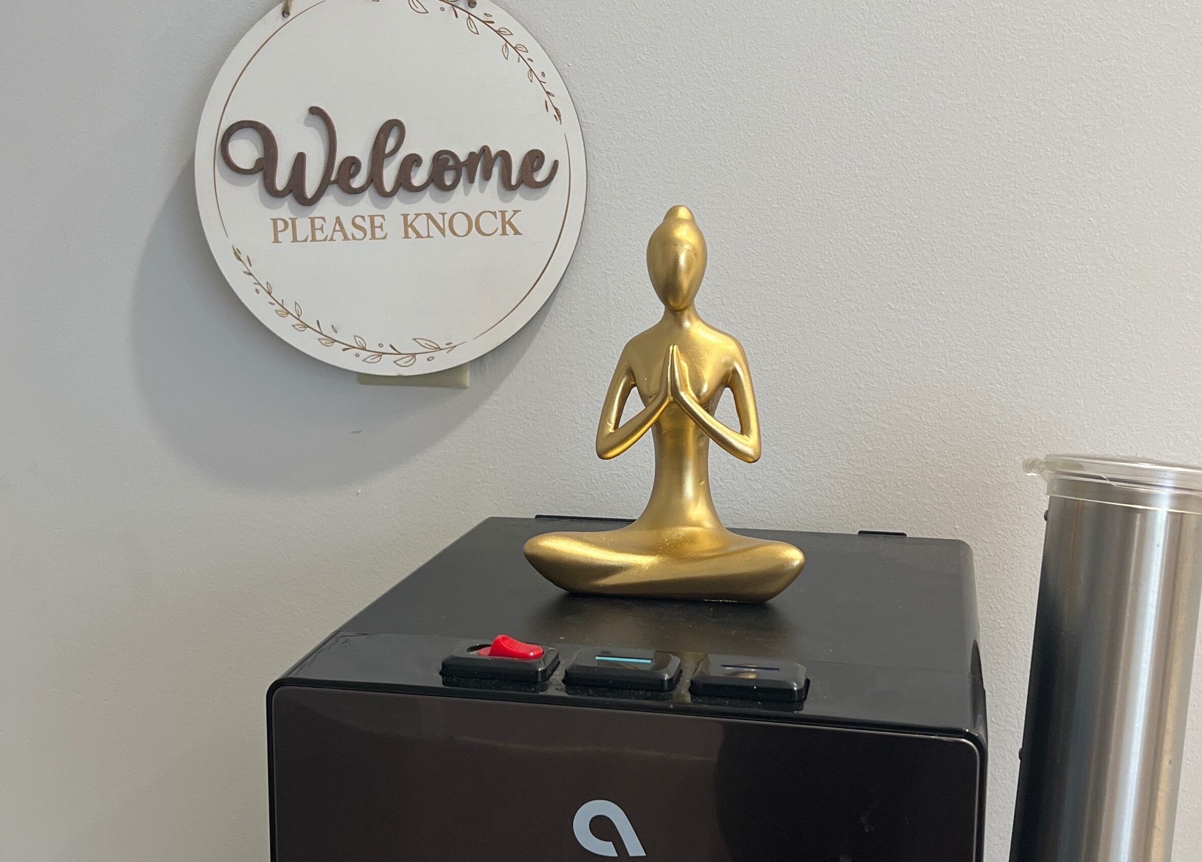 Golden meditation statue at Sol Massage Therapy, Hillsborough Township, New Jersey, US, enhancing a warm welcome.