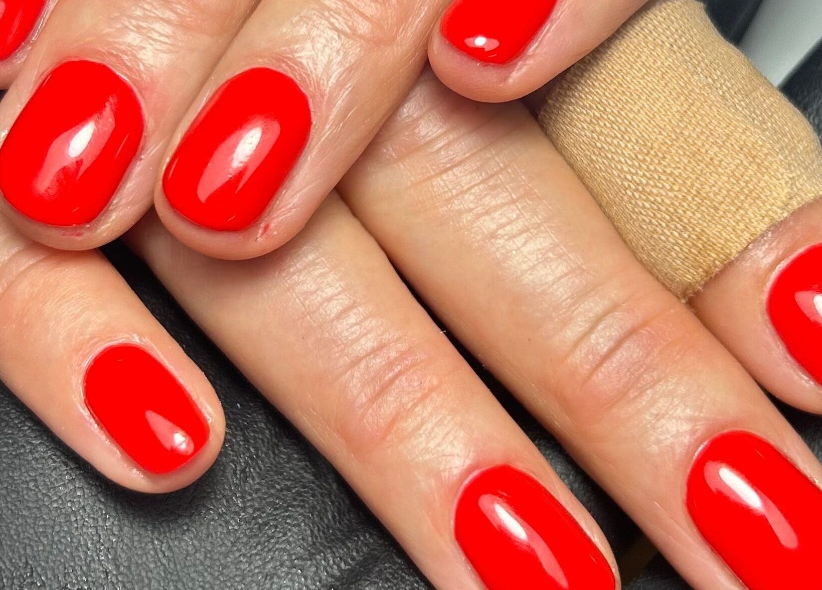 Close-up of vibrant red manicure at Pure Nails by Rachel in Newtown, Wales, GB.
