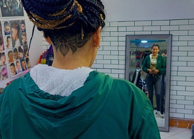 Cliente en Relp Barber, Cusco, Cuzco, PE, mostrando un peinado creativo con diseño artístico en la nuca.