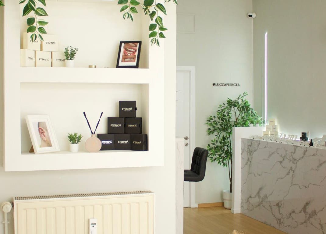 Intérieur élégant chez Eternità Luxury Piercing à Uccle, Bruxelles, BE, avec étagères et comptoir marbré.