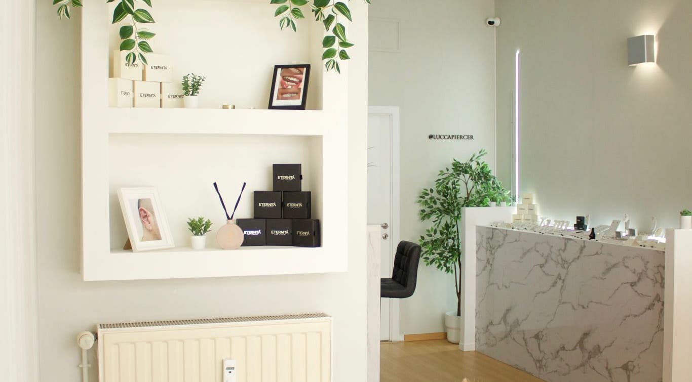 Intérieur élégant chez Eternità Luxury Piercing à Uccle, Bruxelles, BE, avec étagères et comptoir marbré.