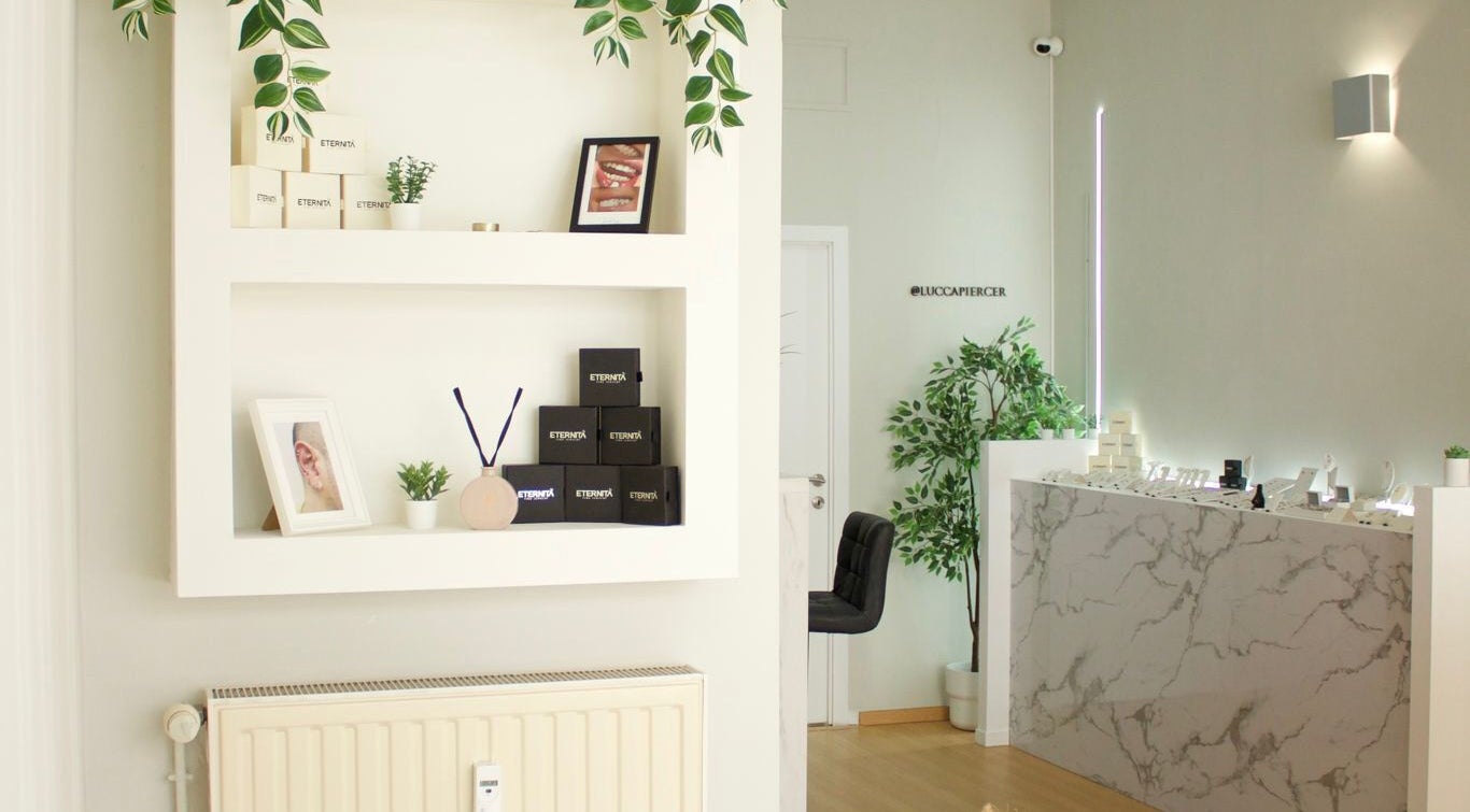 Intérieur élégant chez Eternità Luxury Piercing à Uccle, Bruxelles, BE, avec étagères et comptoir marbré.