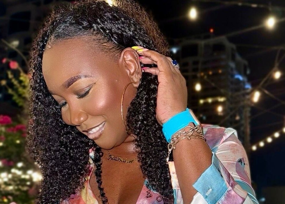 Smiling woman under string lights at Haus Of Lisa J, Bridgetown, Saint Michael, BB.