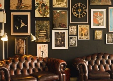 Cozy lounge with leather sofas and eclectic art wall at AB Beauty, Newton Abbot, England, GB.