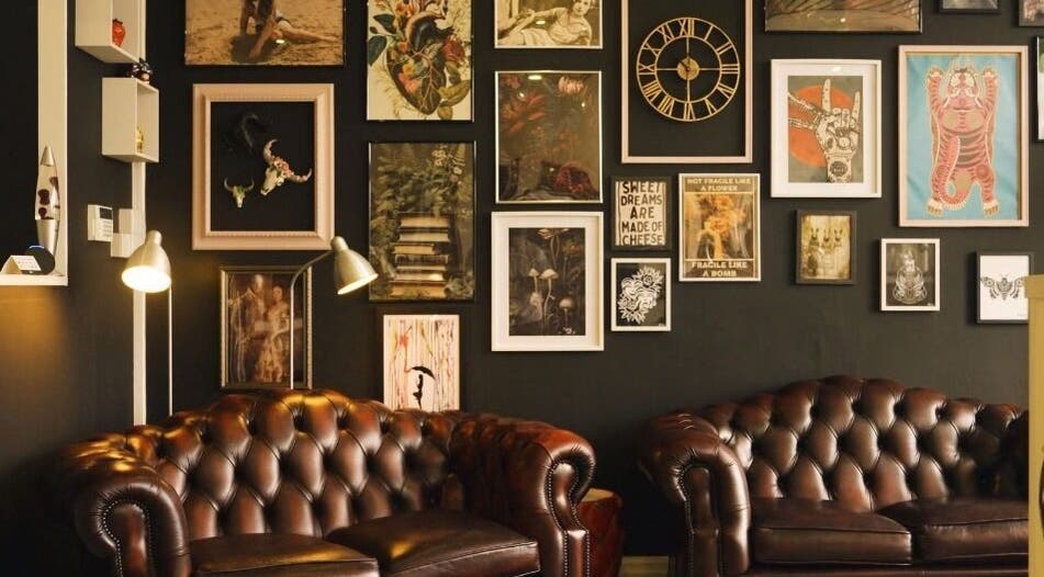 Cozy leather seating in AB Beauty lounge, Newton Abbot, England, with eclectic art wall decor.