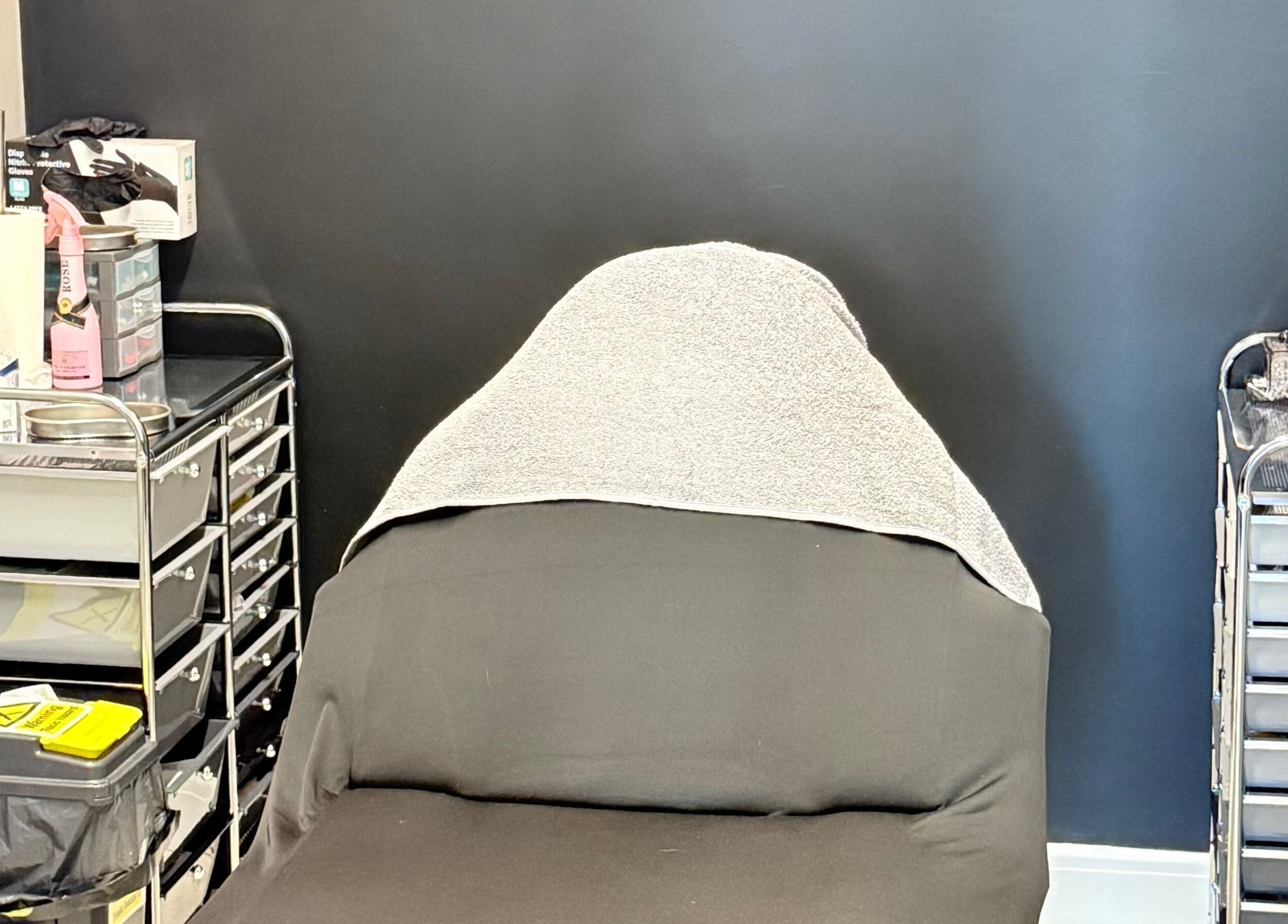 Relaxing treatment room at AB Beauty, Newton Abbot, England, GB, featuring a comfortable chair and organized supplies.