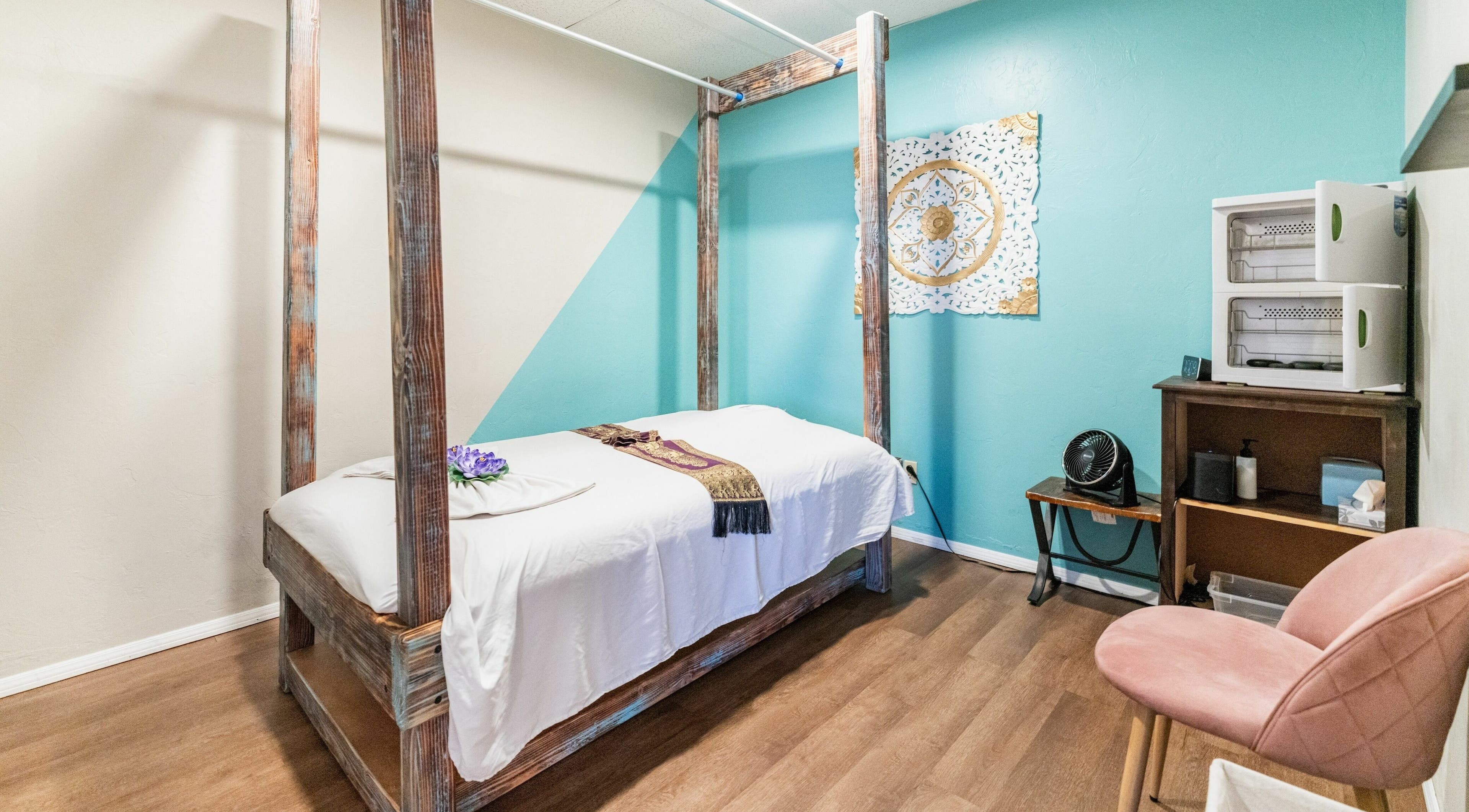Cozy massage room at Ma Thai Massage (Wilmot) in Tucson, Arizona, US with a serene turquoise wall and wood accents.
