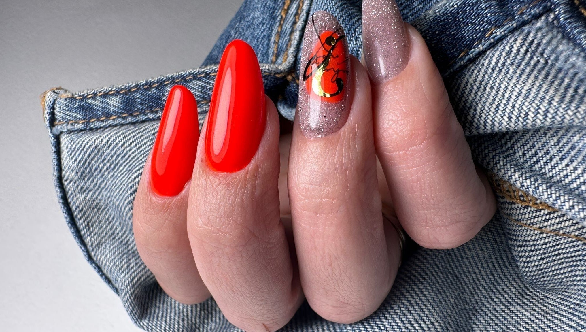 Bright nail art with glossy red and glitter designs at Nails by Amber, Heywood, England, GB.