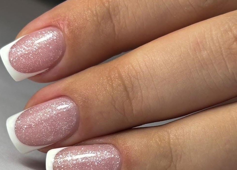 Glistening French manicure at Nails by Amber, Heywood, England, GB, showcasing delicate sparkle and style.