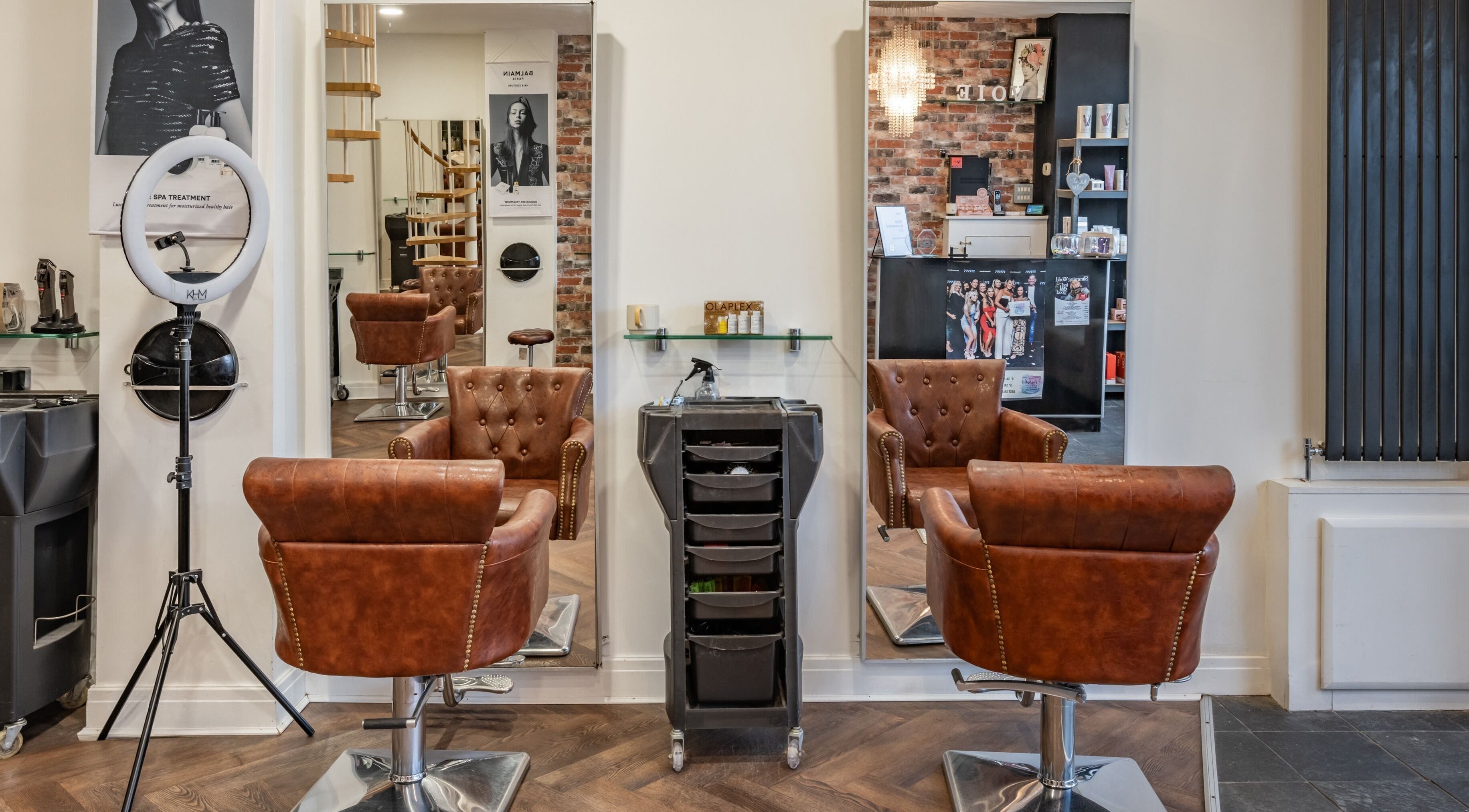 Elegant salon chairs and mirrors at VOIE Hair Leyland in Leyland, England, GB showcasing chic design.