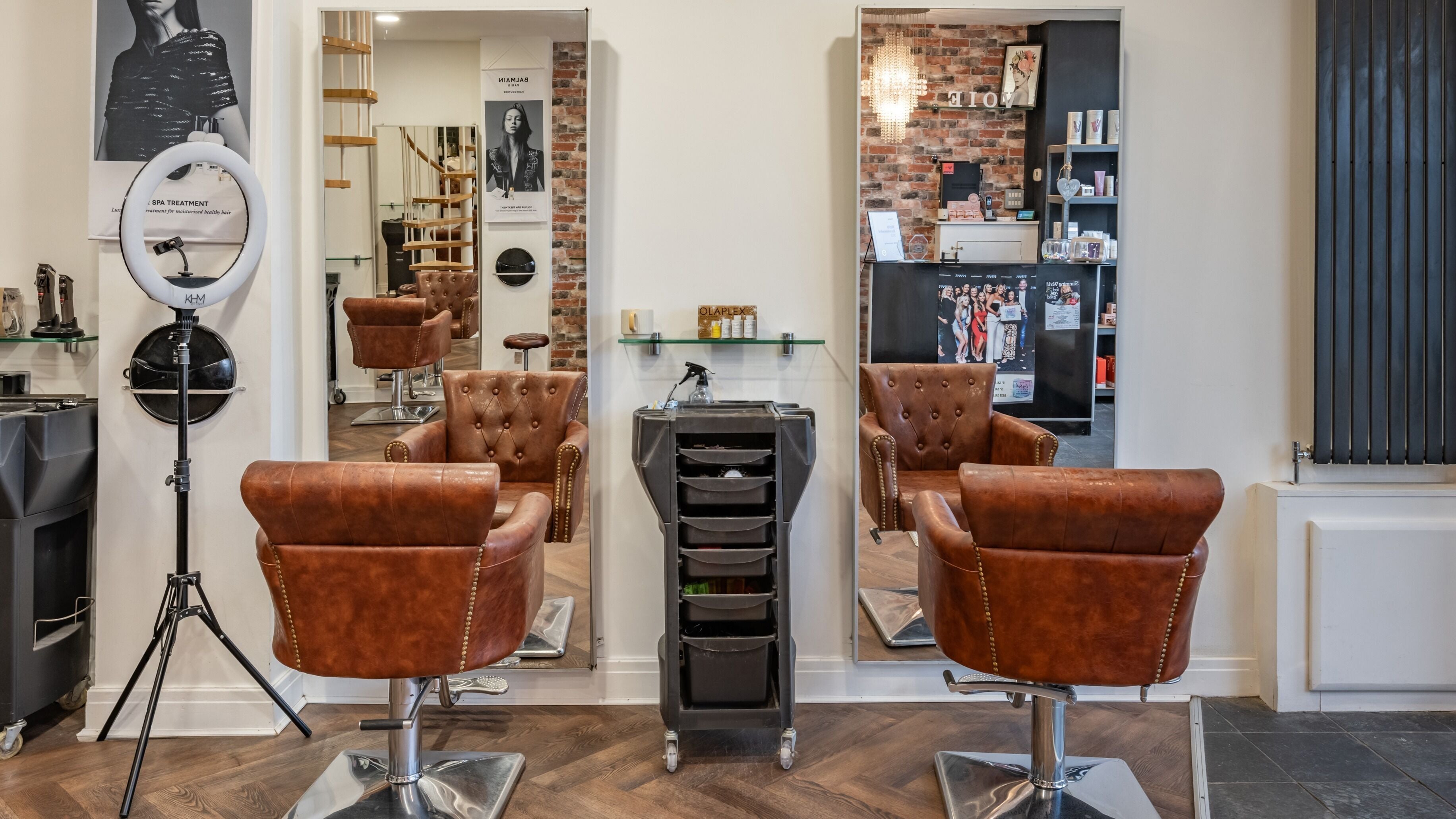 Elegant salon chairs and mirrors at VOIE Hair Leyland in Leyland, England, GB showcasing chic design.
