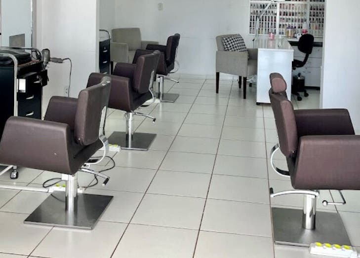 Interior moderno do salão VENANCIO GOMES BEAUTY LOUNGE em Cacoal, RO, BR com cadeiras sofisticadas.