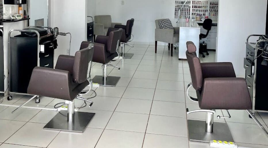 Interior moderno do salão VENANCIO GOMES BEAUTY LOUNGE em Cacoal, RO, BR com cadeiras sofisticadas.