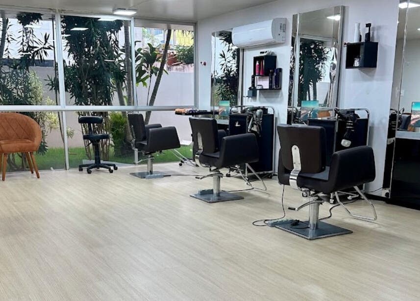 Interior moderno do VENANCIO GOMES BEAUTY LOUNGE em Cacoal, RO, BR com cadeiras e espelhos estilosos.