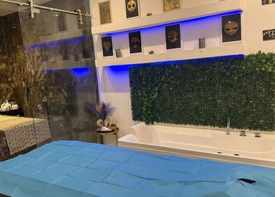 Luxurious spa room at AK SPA in Al Hofuf, Eastern Province, SA featuring a bath and massage table.