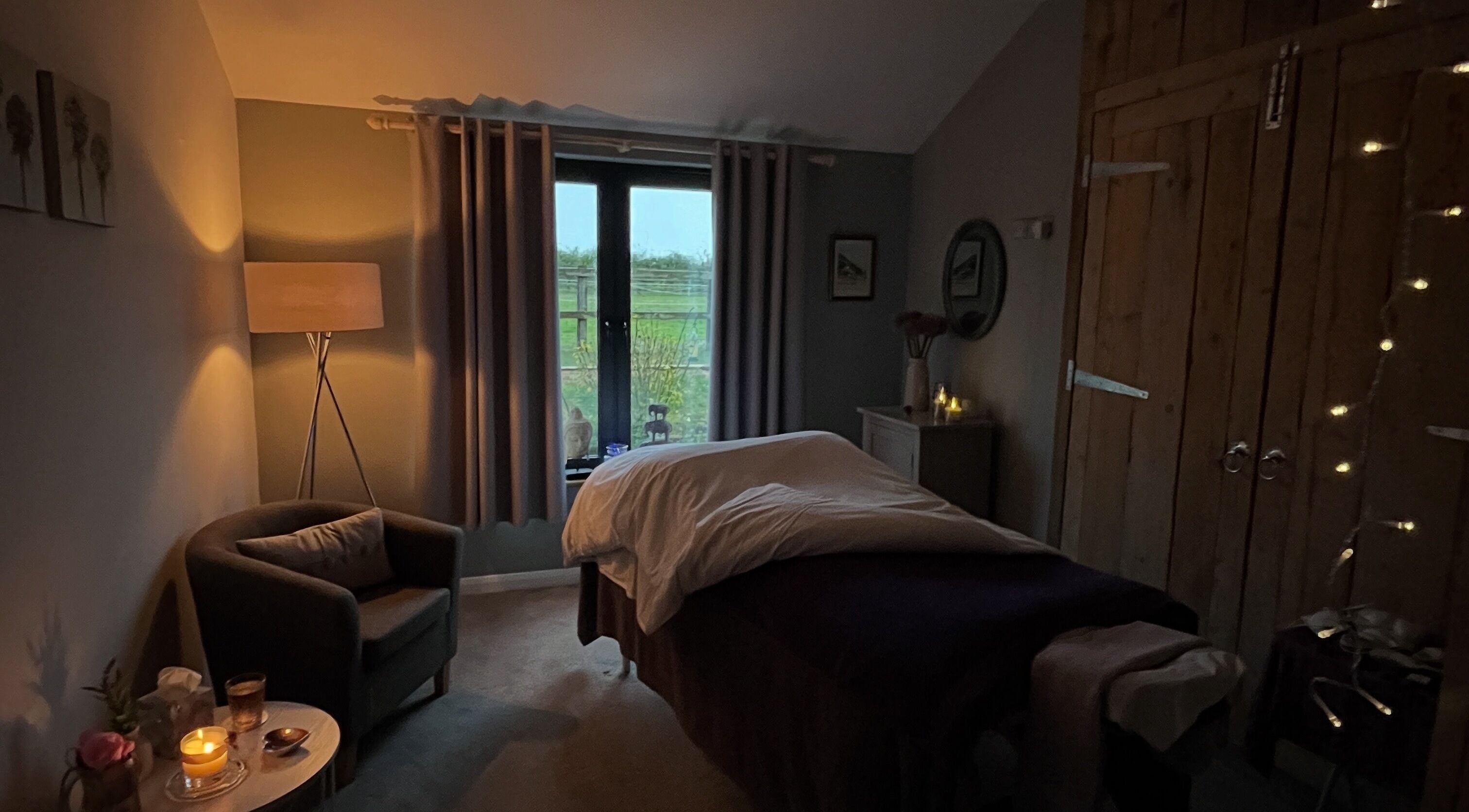 Serene massage room at The Tranquility Skin Barn, Swainsthorpe, England, GB, featuring ambient lighting and soft decor.