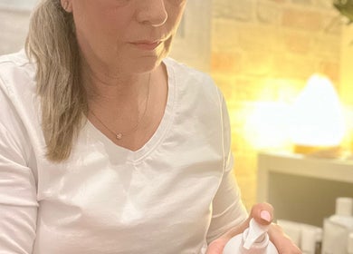 A woman applies skincare product at The Tranquility Skin Barn, Swainsthorpe, England, GB.