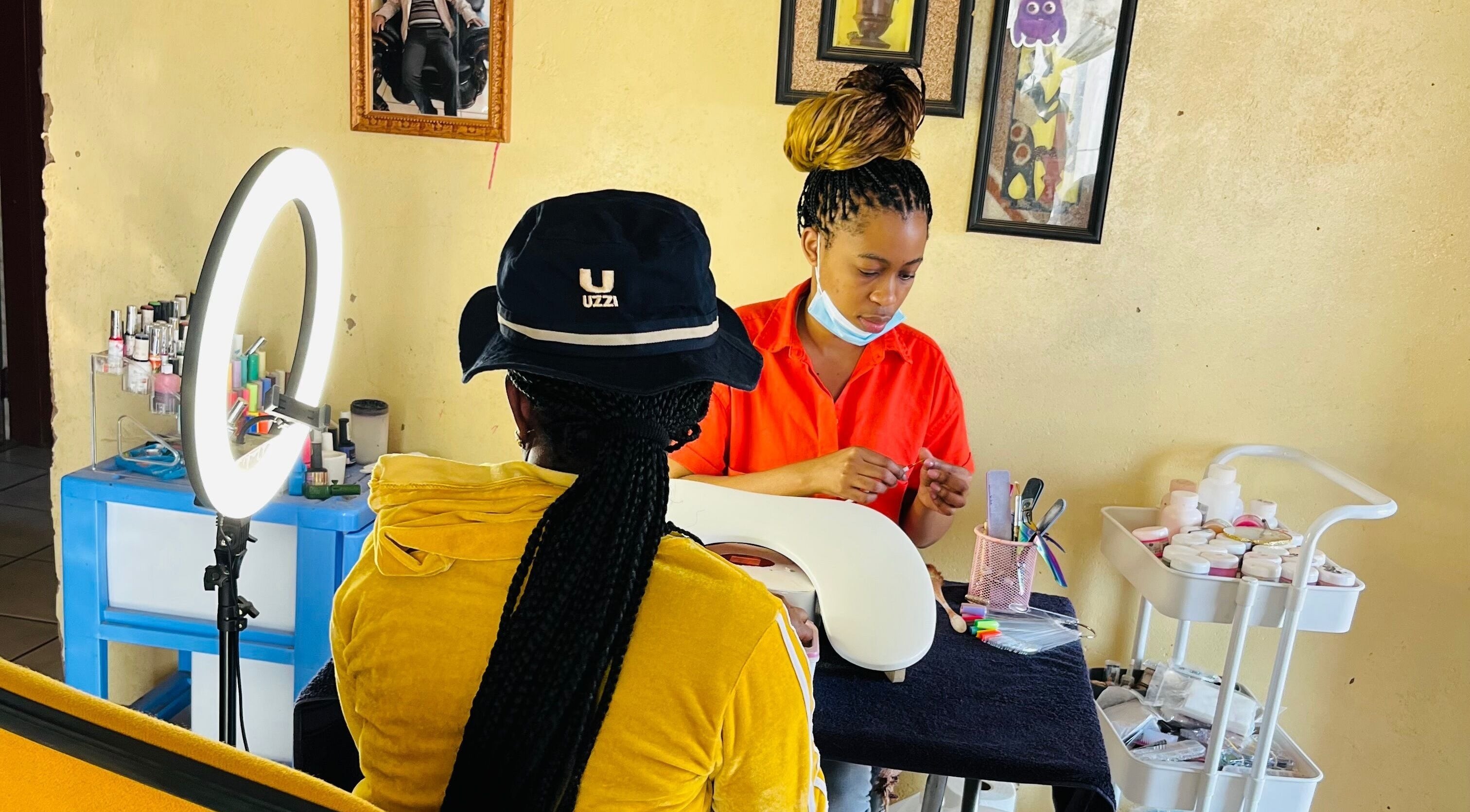 Nail technician working on client at Funky Nails By Sholo, Kuruman, South Africa, ZA with neat setup.