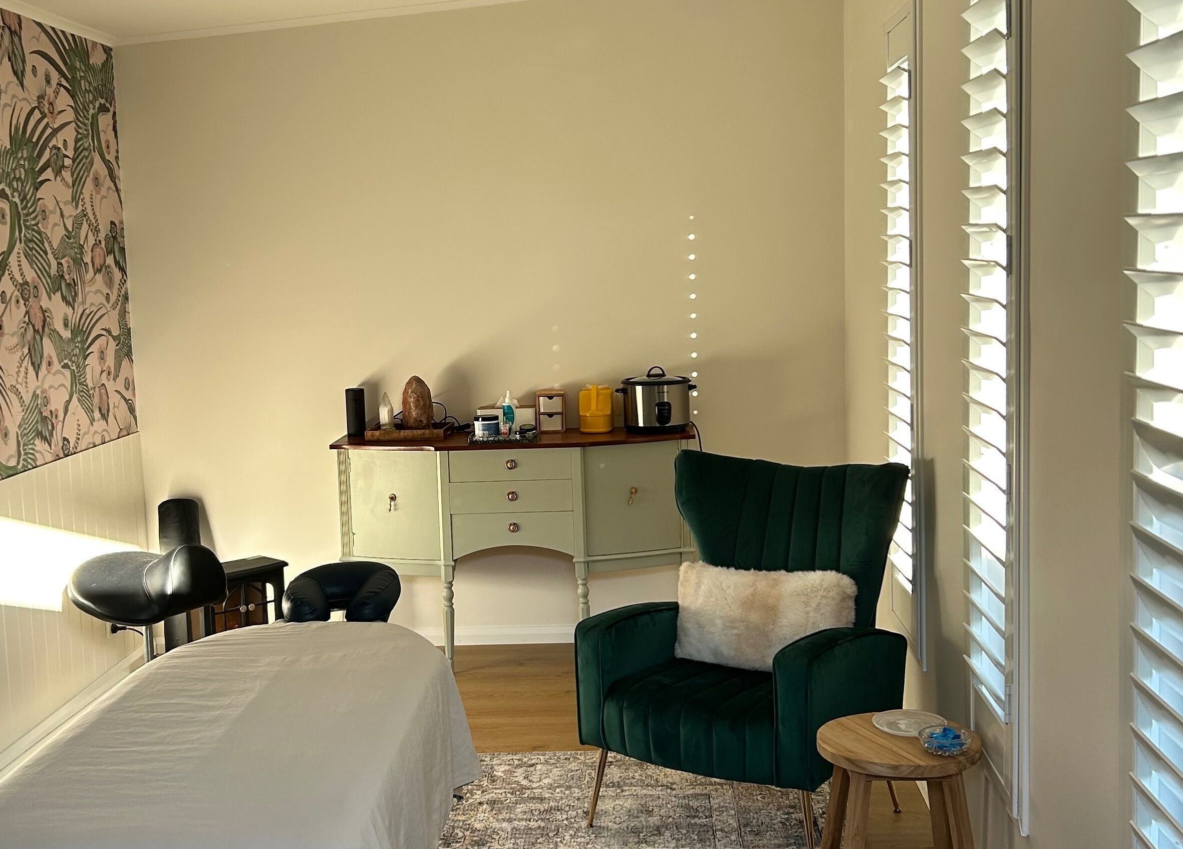 Relaxing space at Absolute Health and Harmony, Berkeley Vale, New South Wales, AU, with a massage bed and cozy chair.